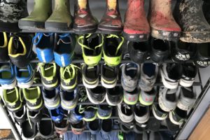 Kids' boots and shoes on a shoe organizer in garage
