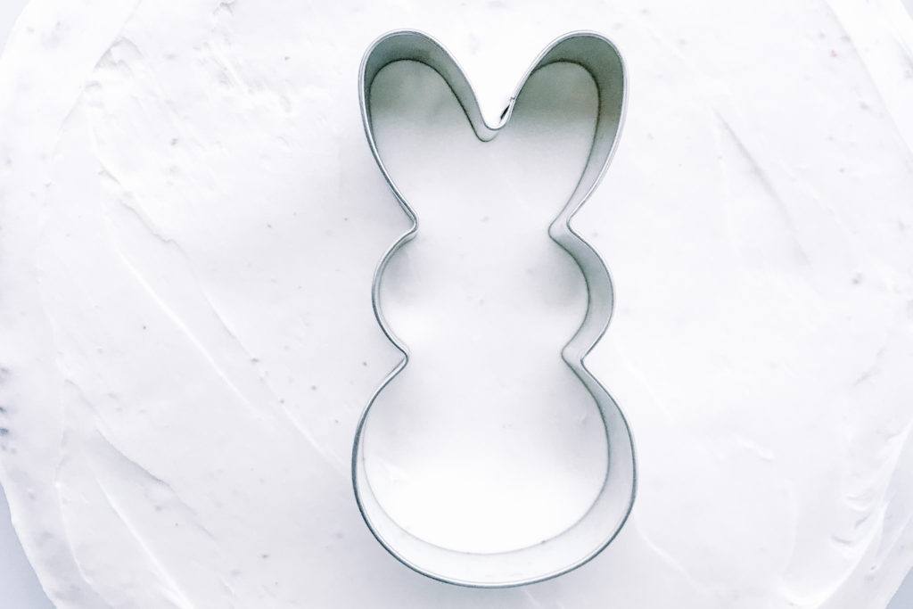 Easter Bunny cookie cutter on top of iced cake