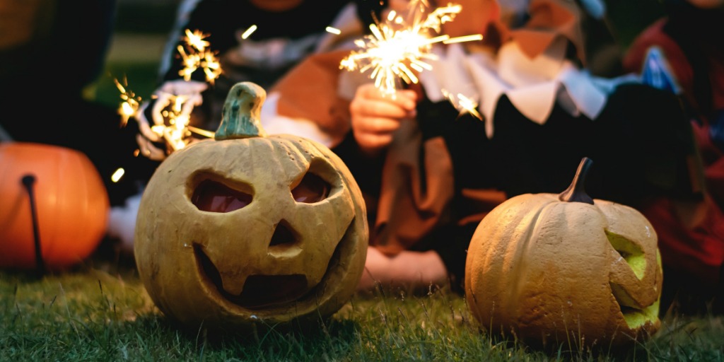 Jack O Lantern with Sparklers being held by children behind it