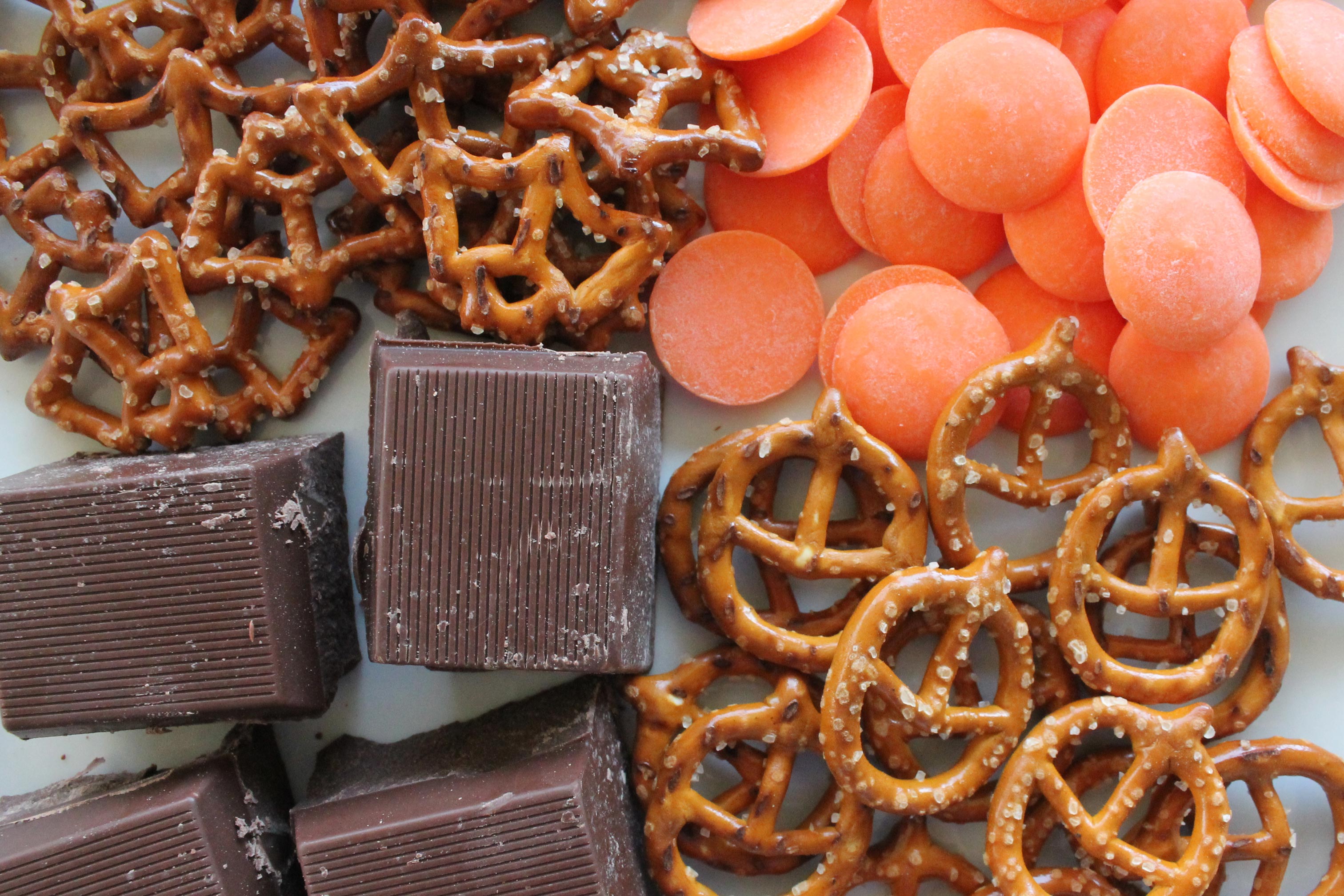 chocolate bark, candy melts, and bat & jack-o-lantern pretzels on a white plate