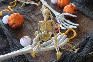 skeleton hand holding a fake skeleton