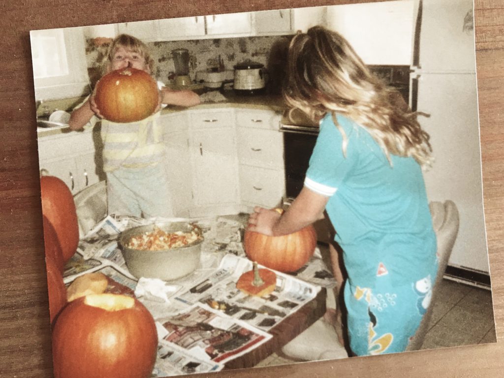 two girls carving pumpkins